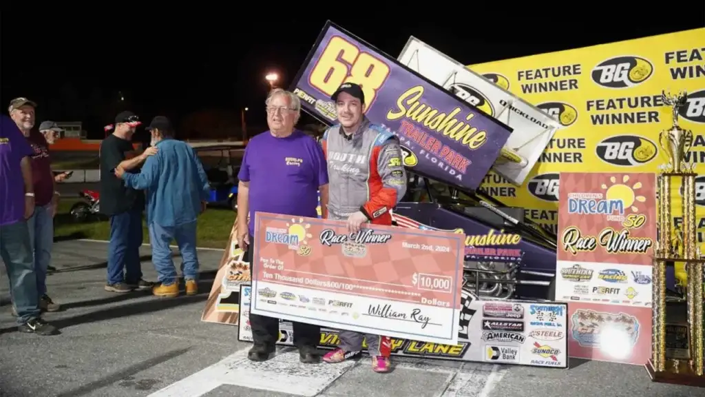 Joe Liguori holds a big check in victory lane after winning the Childrens Dream Fund 50.